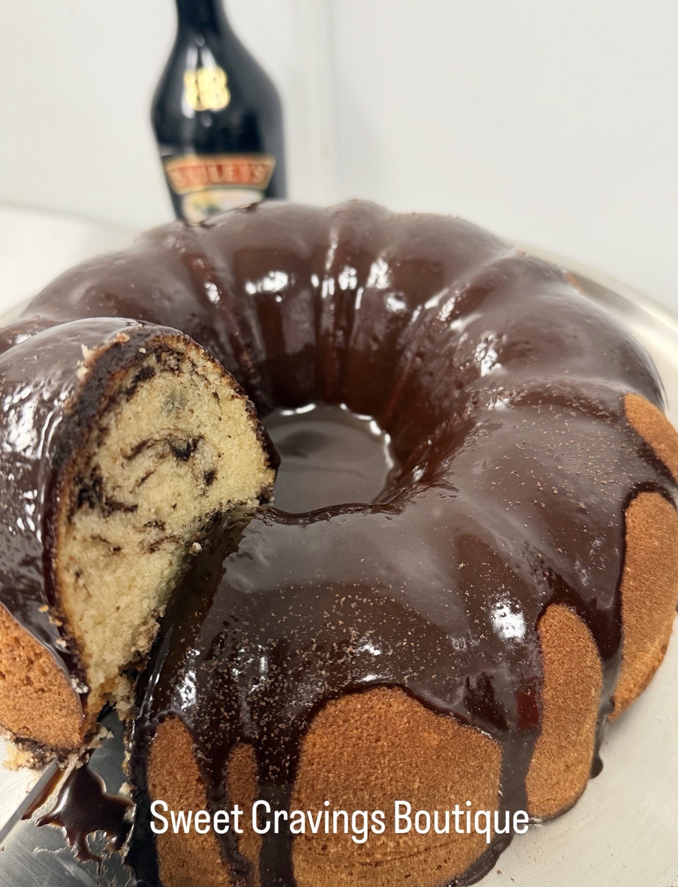 Chocolate-glazed swirled pound cake with a slice showing its interior, by Sweet Cravings Boutique